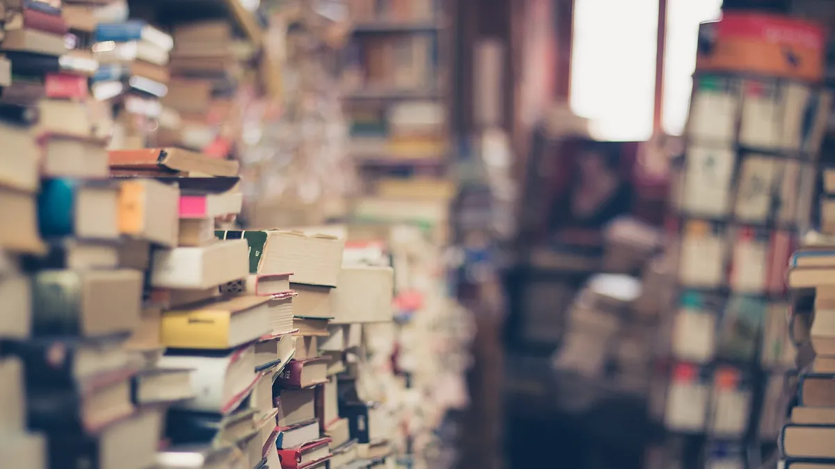A pile of old hardback books with worn cloth spines